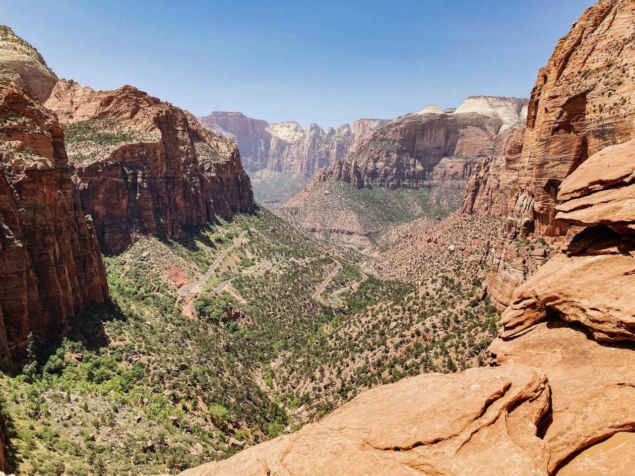 Stunning aerial view of Zion National Park's rugged canyons and vibrant landscape under a clear blue sky.